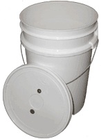 Two stacked white plastic buckets with a detached lid leaning on them.